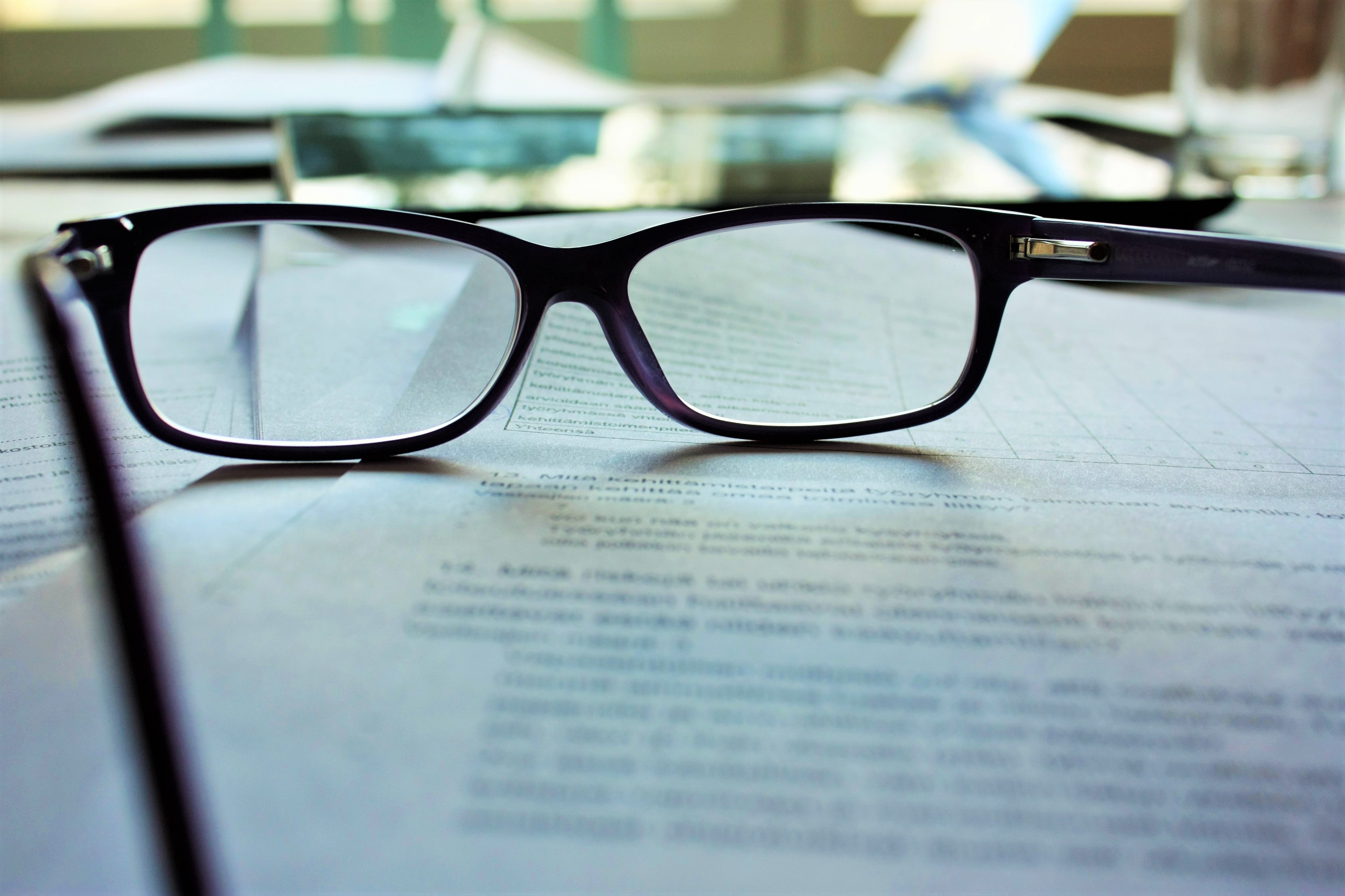 Gafas colocadas sobre el contrato de arrendamiento de una persona cansada de leer