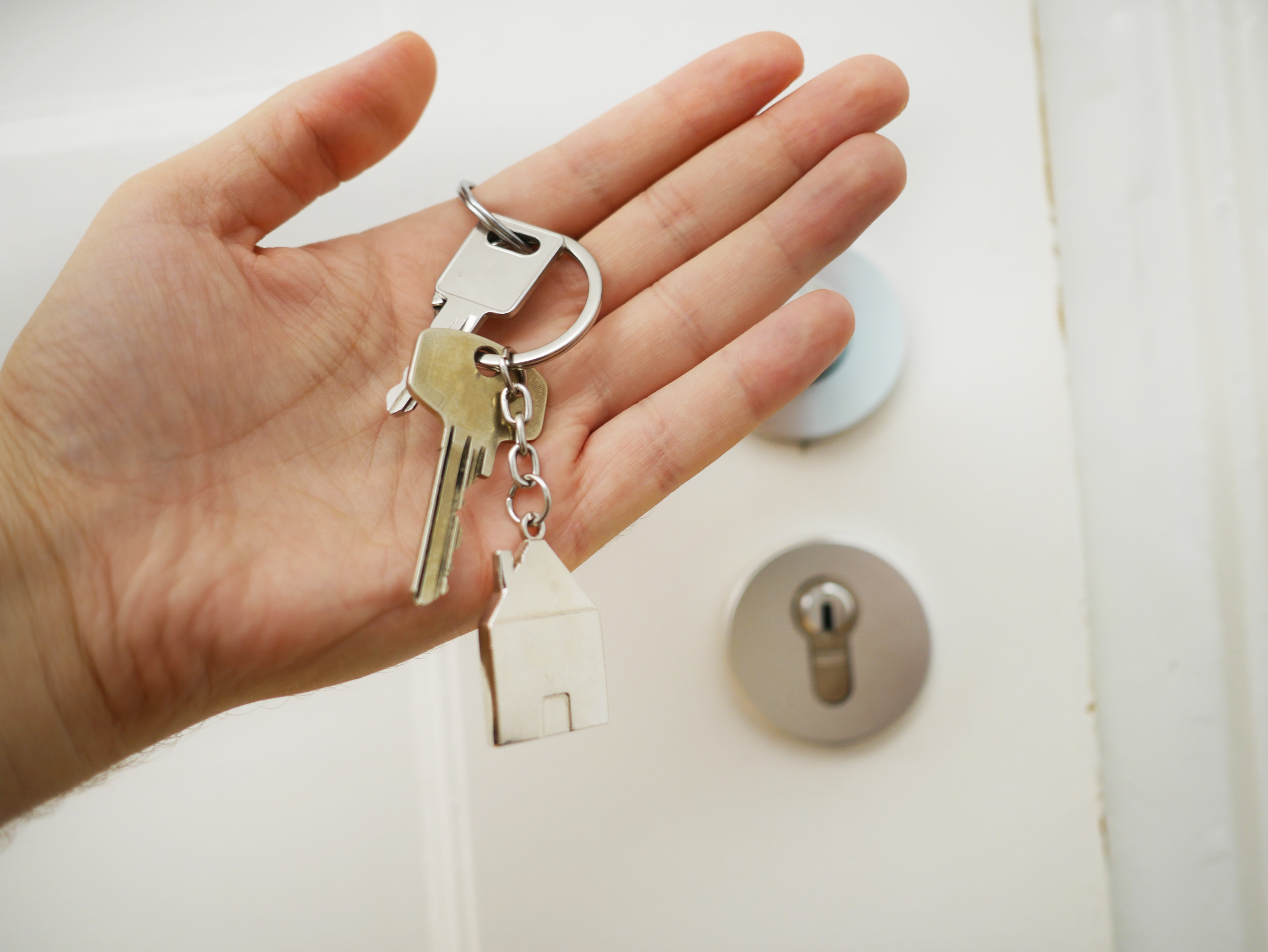 Persona abriendo la puerta de su nuevo hogar tras haber firmado un contrato de arrendamiento 100% confiable